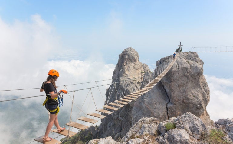 Woman Crossing Mountain Bridge